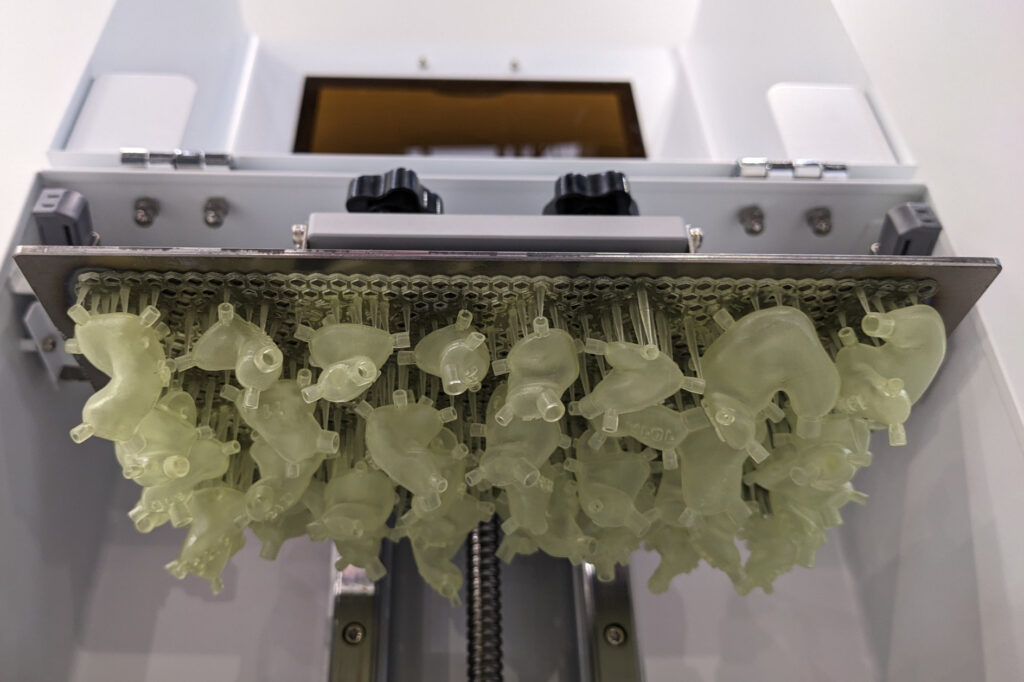 Ein 3D-Drucker mit vielen gelblichen Otoplastiken